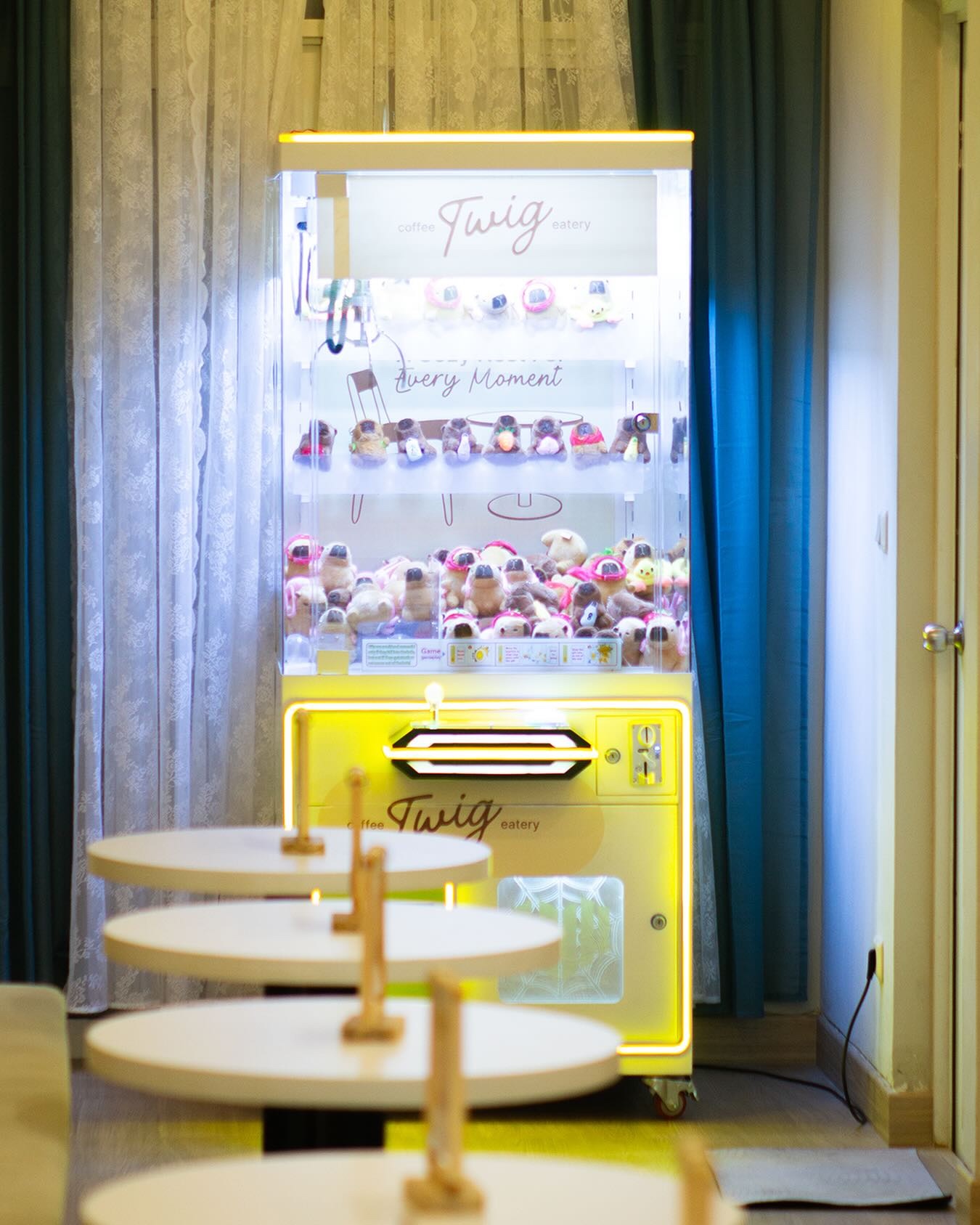 Twig's yellow prize machine beside the round tables on the first floor