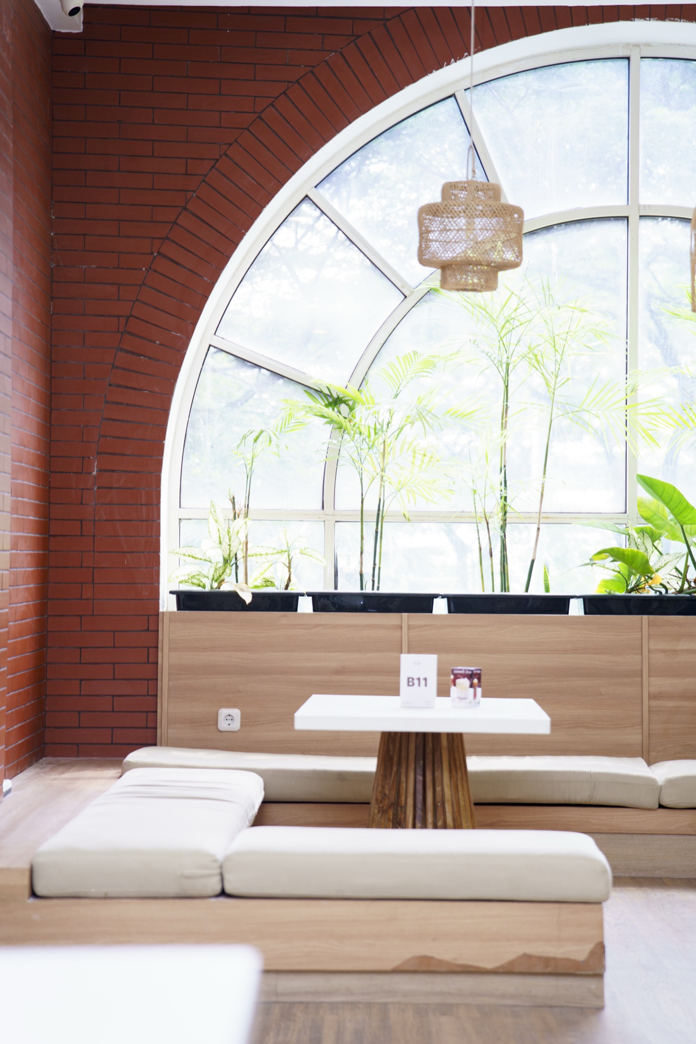 Banquette seating under the arched window against the brick wall